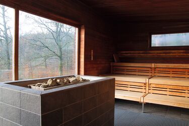 Innenansicht einer Saunakabine im Molzbergbad mit Panoramafenster in die Natur.